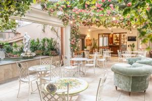 d'une terrasse avec des tables, des chaises et des fleurs. dans l'établissement Adler Cavalieri Hotel-Private Spa & Gym, à Florence