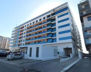 a large building with a car parked in front of it at 1BHK Near Airport, Pool, Parking in Muscat