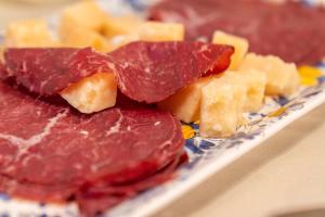 a pile of meat and cheese on a plate at Adler Cavalieri Hotel-Private Spa & Gym in Florence
