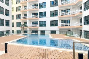 una piscina frente a un edificio en 1BHK Near Airport, Pool, Parking en Mascate