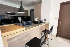 a kitchen with a wooden counter with a black chair at 1BHK Near Airport, Pool, Parking in Muscat
