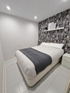 Un dormitorio blanco con una cama grande y una pared en La casita de Antonella - centro de Comillas, en Comillas