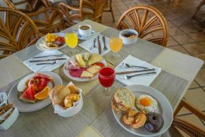 uma mesa com pratos de comida para o pequeno almoço em Hotel Arena Suite em Corralejo