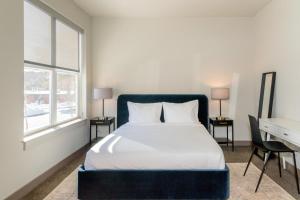 a bedroom with a bed with a blue headboard and a desk at Burlington 2br w gym wd nr dining shops BOS-977 in Burlington