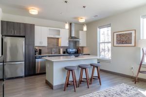 a kitchen with white cabinets and bar stools at Burlington 2br w gym wd nr dining shops BOS-977 in Burlington