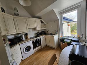 a small kitchen with white cabinets and a window at Scotts Lodge Newcastle County Down in Newcastle