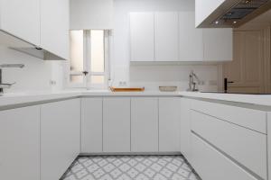 una cocina blanca con armarios blancos y fregadero en Spacious bright- 2Bd 2Bth- Recoletos en Madrid