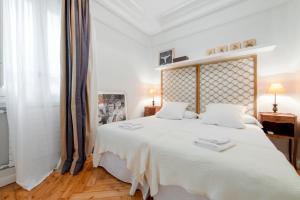 1 dormitorio blanco con 1 cama grande con sábanas blancas en Spacious bright- 2Bd 2Bth- Recoletos en Madrid