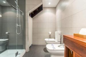 uma casa de banho com 2 WC e uma cabina de duche em vidro. em Modern- 2Bd 2Bth - Ópera em Madri