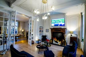 a living room with a tv and a fireplace at St-Georges IV in Ieper