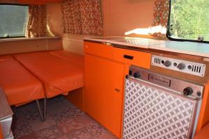una pequeña cocina con armarios naranjas y fogones. en La Eriba Toinette en Nort-sur-Erdre