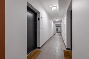 een hal met witte muren en een zwarte deur bij Raginisa Modern Apartments in Szczecin
