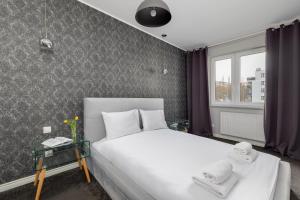 een slaapkamer met een groot wit bed en een raam bij Raginisa Modern Apartments in Szczecin