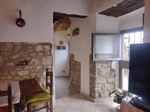 sala de estar con chimenea de piedra y TV en La casa di Polly, en Pelago