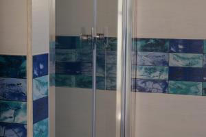 una doccia con piastrelle bianche e blu sul muro di Case vacanze la Quercia a Marina di Camerota