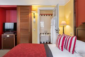 ジュネーヴにあるキプリング マノテルのベッドとバスルーム付きのホテルルームです。