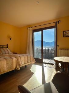 a bedroom with a bed and a large window at Hotel Cal Martri in Ger