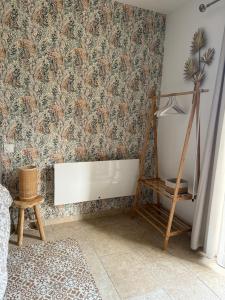 una habitación con una pared cubierta de papel pintado con motivos florales en Terre et Mer en Favières