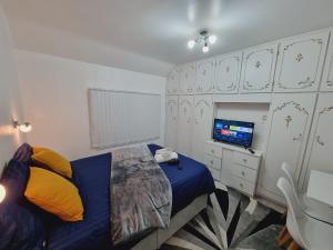 a bedroom with a bed and a tv and cabinets at Luxury double bed with Private Bathroom, NETFLIX, work space and WiFi in Leeds