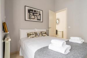 um quarto com uma cama branca e 2 toalhas brancas em Stylish and Bright - 2Bd 1Bth- Atocha em Madri