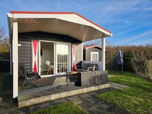 einen kleinen Pavillon mit einer Terrasse im Hof in der Unterkunft Chalet Noelle SE14 in Serooskerke