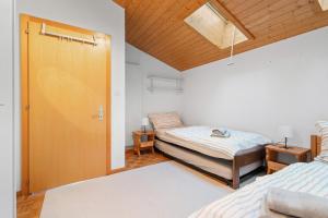 - une chambre avec deux lits et un plafond en bois dans l'établissement Valaisia 55B - plein centre, à Nendaz