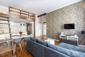 uma sala de estar com um sofá azul e uma televisão em Fresh Apartments em Cracóvia