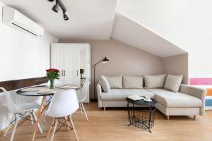 a living room with a couch and a table and chairs at Fresh Apartments in Kraków