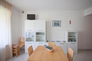 eine Küche mit einem Holztisch und weißen Schränken in der Unterkunft La Casa Di Lavinia in Nago-Torbole