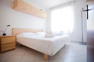 ein Schlafzimmer mit einem großen weißen Bett und einem Fenster in der Unterkunft La Casa Di Lavinia in Nago-Torbole