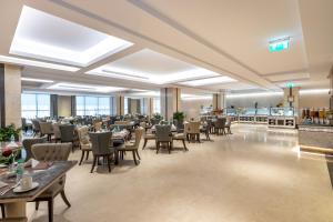View Al Madinah Hotel في المدينة المنورة: مطعم بطاولات وكراسي في مبنى