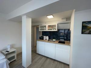 uma cozinha com armários brancos e uma bancada em apartmantt em Cheb