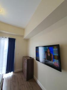 a living room with a flat screen tv on the wall at Arlowes Cebu at 20f Grand Residences Cebu in Cebu City