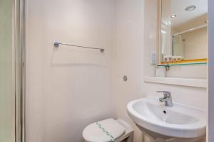 a white bathroom with a sink and a toilet at Ensuite Room With Shared Kitchen, Close to Centre in Lincoln