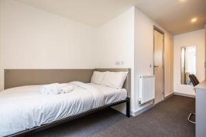 a bedroom with a white bed with towels on it at Ensuite Room With Shared Kitchen, Close to Centre in Lincoln