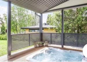 a hot tub on a deck with a fence at Hienoa talo porealtaalla lähelllä Helsinkiä ja lentokenttää in Tuusula