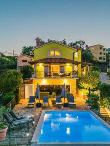 a house with a swimming pool in front of it at Villa Izzi Opatija in Opatija
