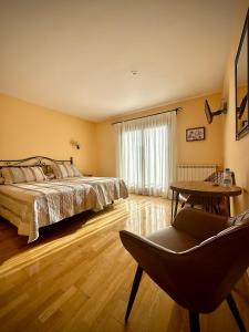GerにあるHotel Cal Martriのベッドルーム1室(ベッド1台、椅子、テーブル付)