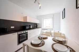 a white kitchen with a table and chairs in it at HA01 Großes Apartment am Hafen! in Worms