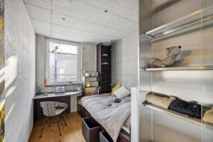 Habitación pequeña con cama y escritorio. en Lumen by coliving en Renens