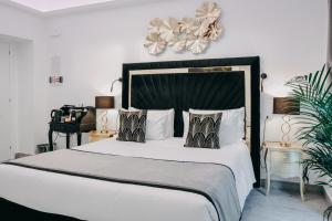 een slaapkamer met een groot bed met witte lakens en kussens bij Imperial Rhome Guest House in Rome