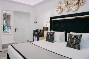 a bedroom with a large white bed with a black headboard at Imperial Rhome Guest House in Rome