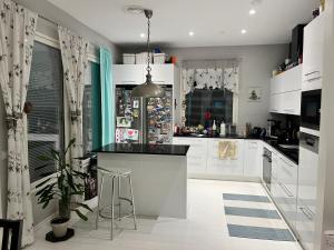 a kitchen with white cabinets and a black counter top at Hienoa talo porealtaalla lähelllä Helsinkiä ja lentokenttää in Tuusula