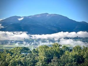 a view of a mountain with clouds and trees at Hotel Cal Martri in Ger