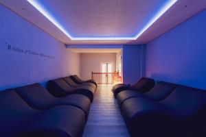 a room with a row of blue leather couches at Hotel Diamant Park in Campitello di Fassa