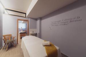 a bedroom with a bed and a chair in a room at Hotel Diamant Park in Campitello di Fassa