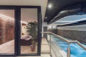 a house with a swimming pool and a glass door at Hotel Diamant Park in Campitello di Fassa
