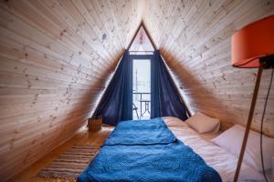 a bed in a room with a large window at Savalley Kazbegi in Kazbegi