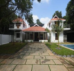 a villa with a swimming pool and a house at Courtyard Castle Heritage Resort - Private Villa & Rooms in Pondicherry