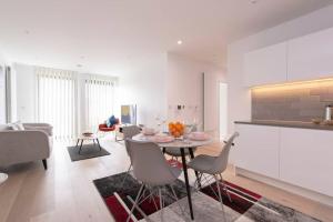 a kitchen and living room with a table and chairs at Utopian Modern Apartments in London